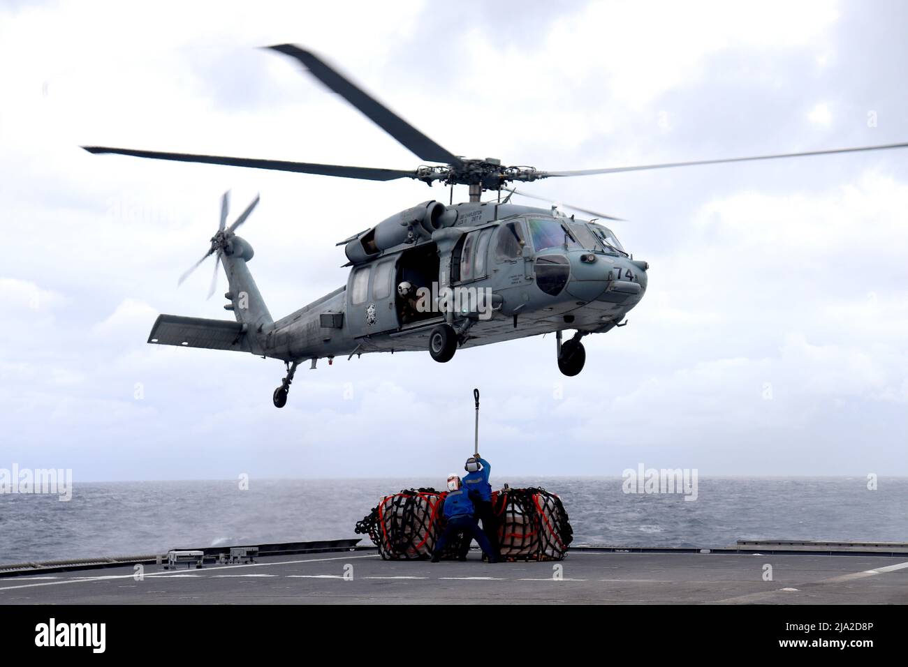 PHILIPPINE SEA (May 18, 2022) Boatswain's Mate 3rd Class Kameron Clinton,  from Eustis, Florida, signals to the pilots in an MH-60R Seahawk during  flight operations aboard Arleigh Burke-class guided-missile destroyer USS  Dewey (