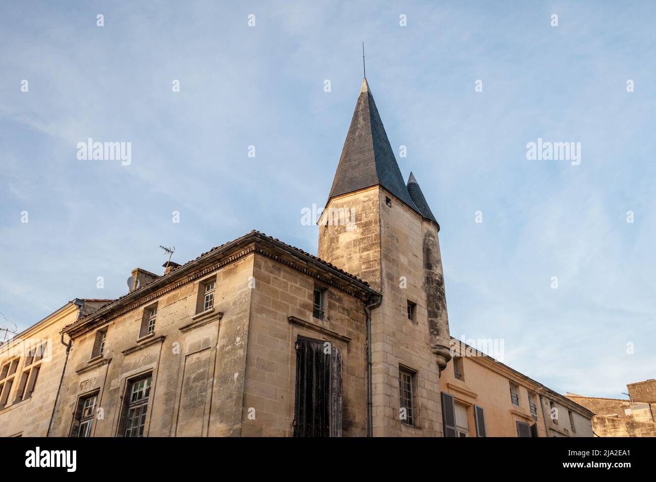Picture of an old medieval tower and a facade of a residential building in the city center of Libourne, France. Libourne is a commune in the Gironde d Stock Photo