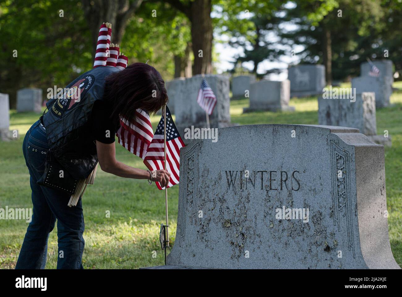 Dallas, United States. 25th May, 2022. A woman replaces a flag on a gravesite for Memorial Day. Members of the American Legion, Boy Scouts and Girl Scouts have been replacing tattered flags throughout cemeteries in preparation for the Memorial Day Holiday. (Photo by Aimee Dilger/SOPA Images/Sipa USA) Credit: Sipa USA/Alamy Live News Stock Photo