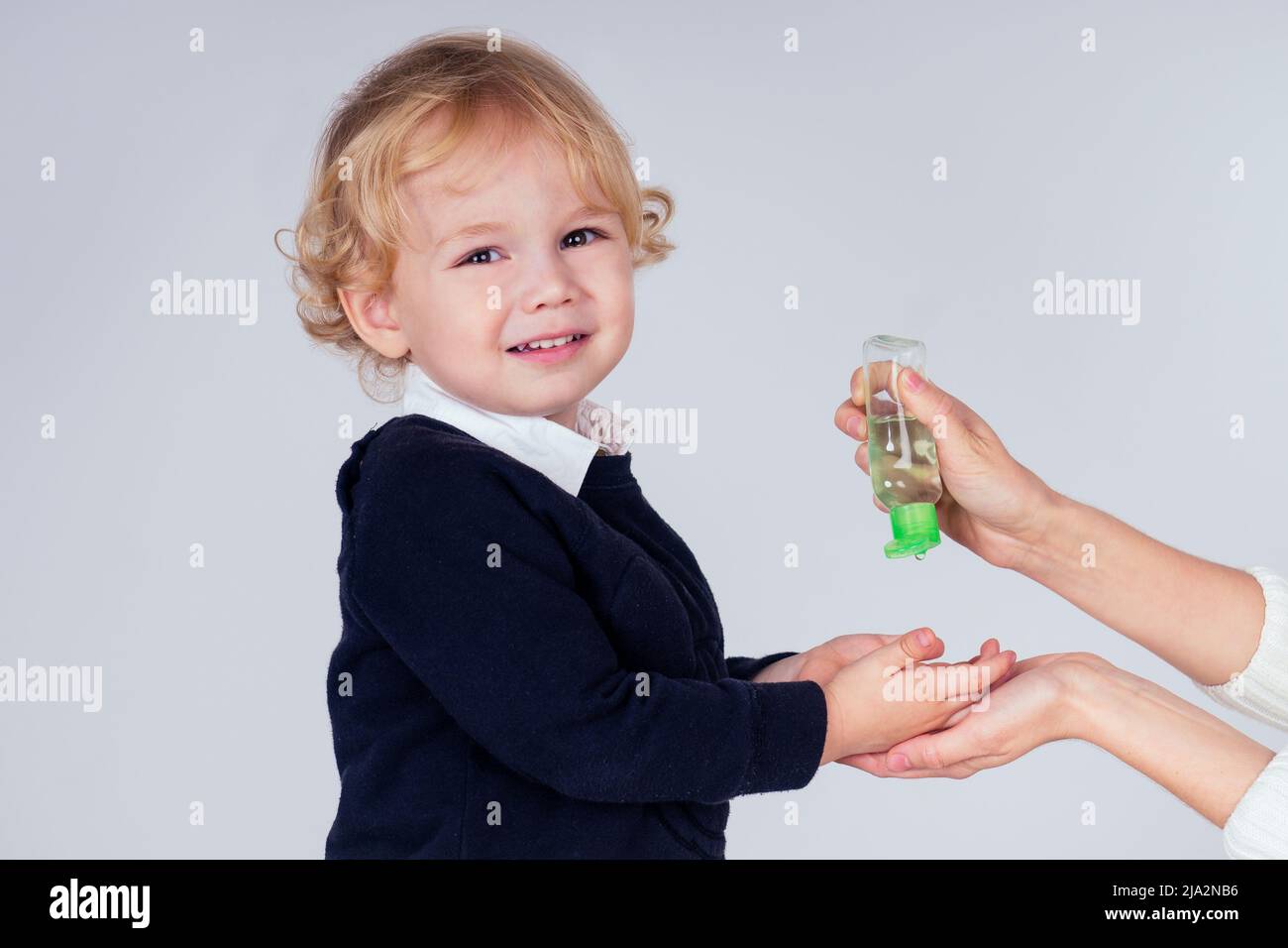 portrait of a cute little blond boy applying antibacterial antiseptic
