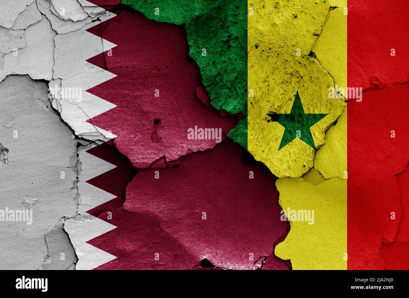 flags of Qatar and Senegal painted on cracked wall Stock Photo