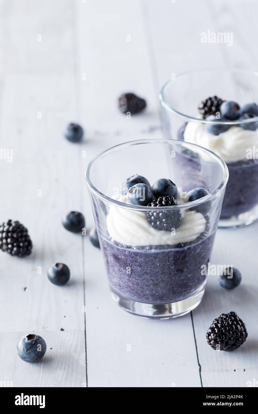 Blueberry chia pudding parfaits topped with vanilla yogurt and berries. Stock Photo