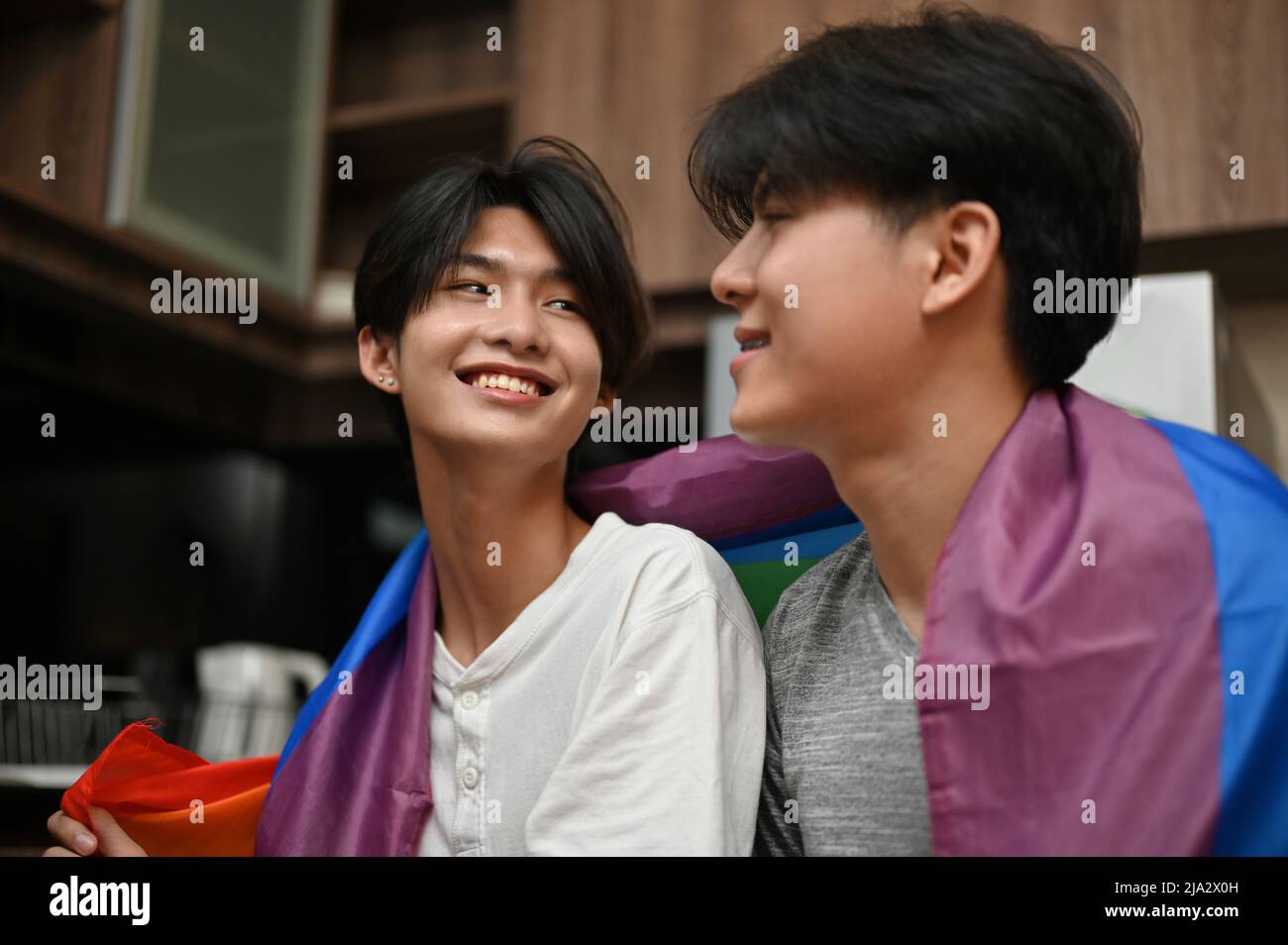 LGBT couples concept, Asian teenage gay men's couple face to face, sharing a special romantic love feeling for each other in the kitchen. Stock Photo