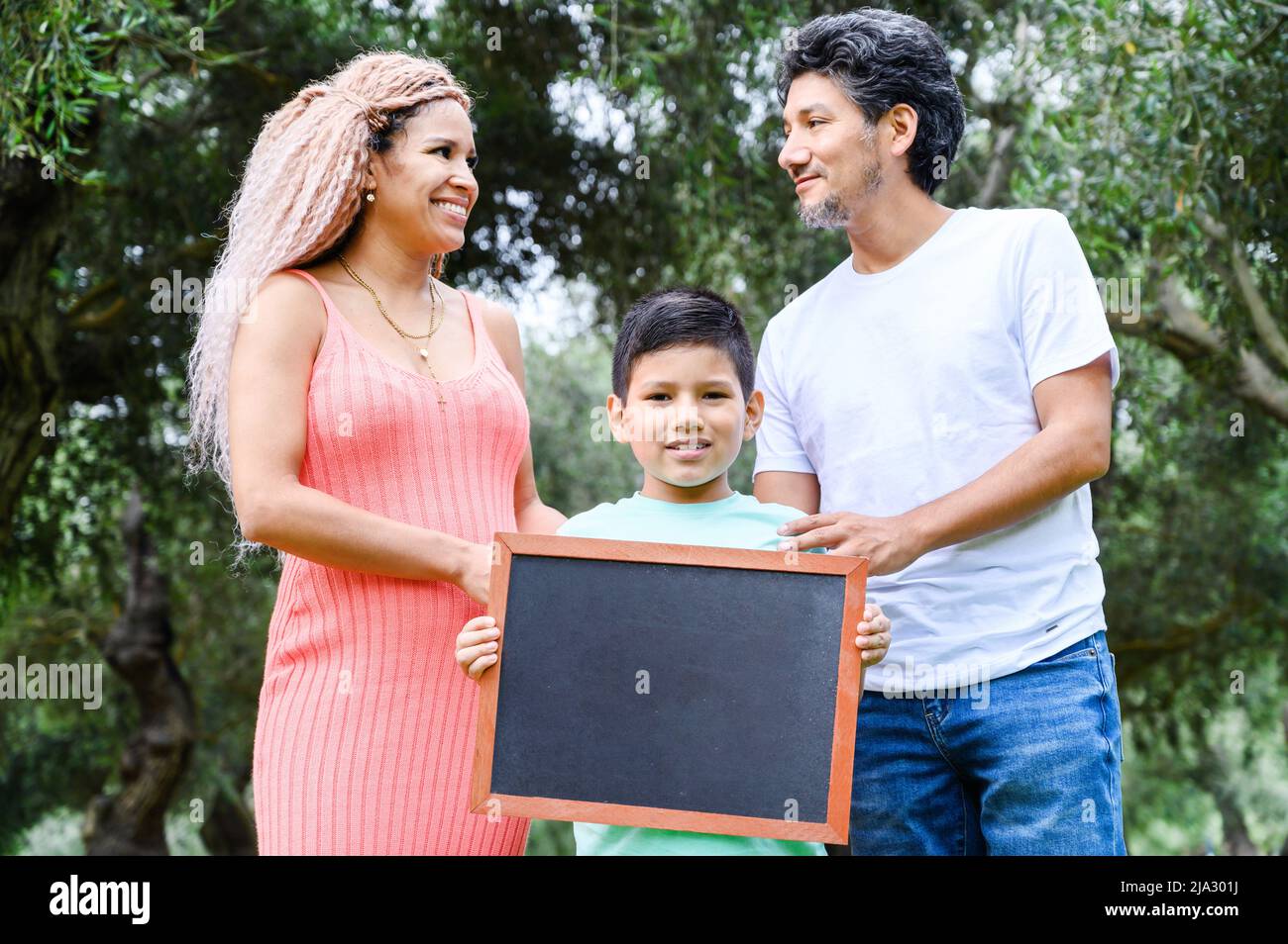 Beautiful happy family holding a blackboard with free space for text Stock Photo
