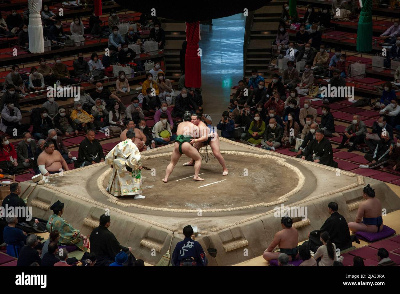 Two sumo wrestlers grappling during a bout in the Grand Sumo Tournament at the Ryogoku Kokugikan stadium in Tokyo, January 2022. Stock Photo