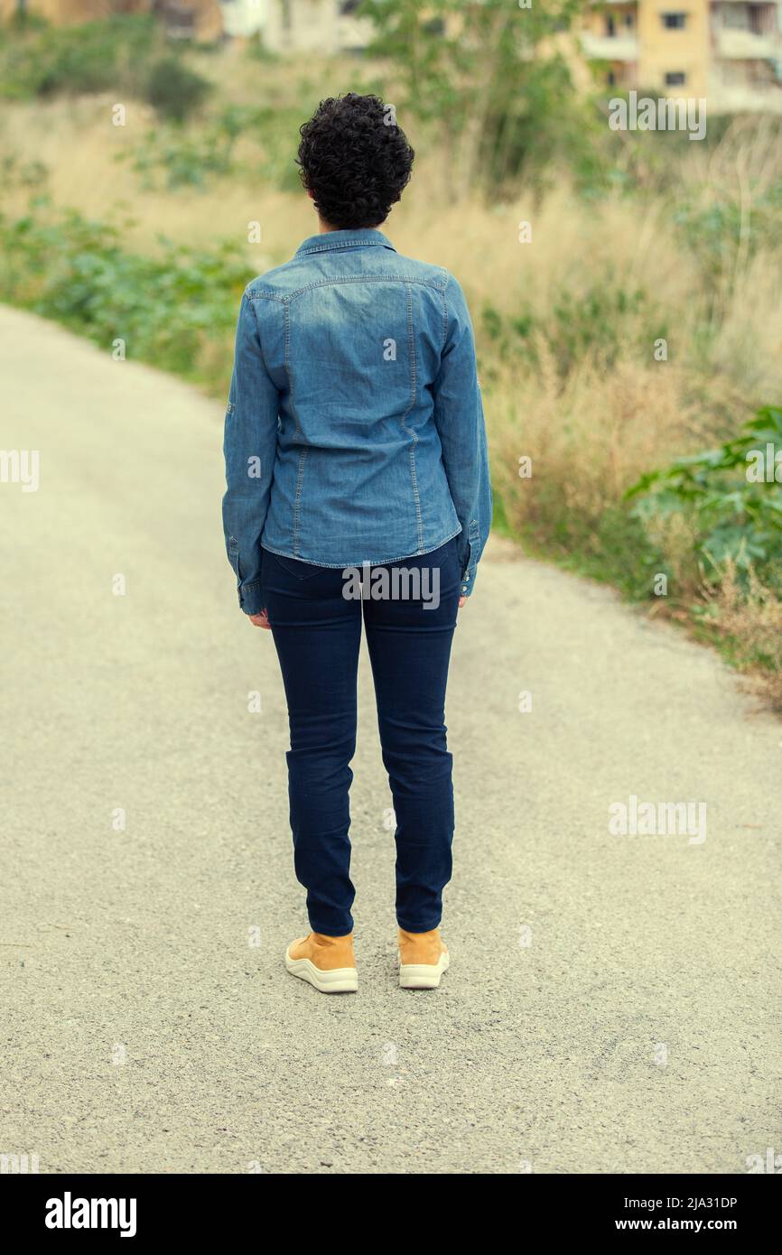 Rear view of woman standing on the roud Stock Photo