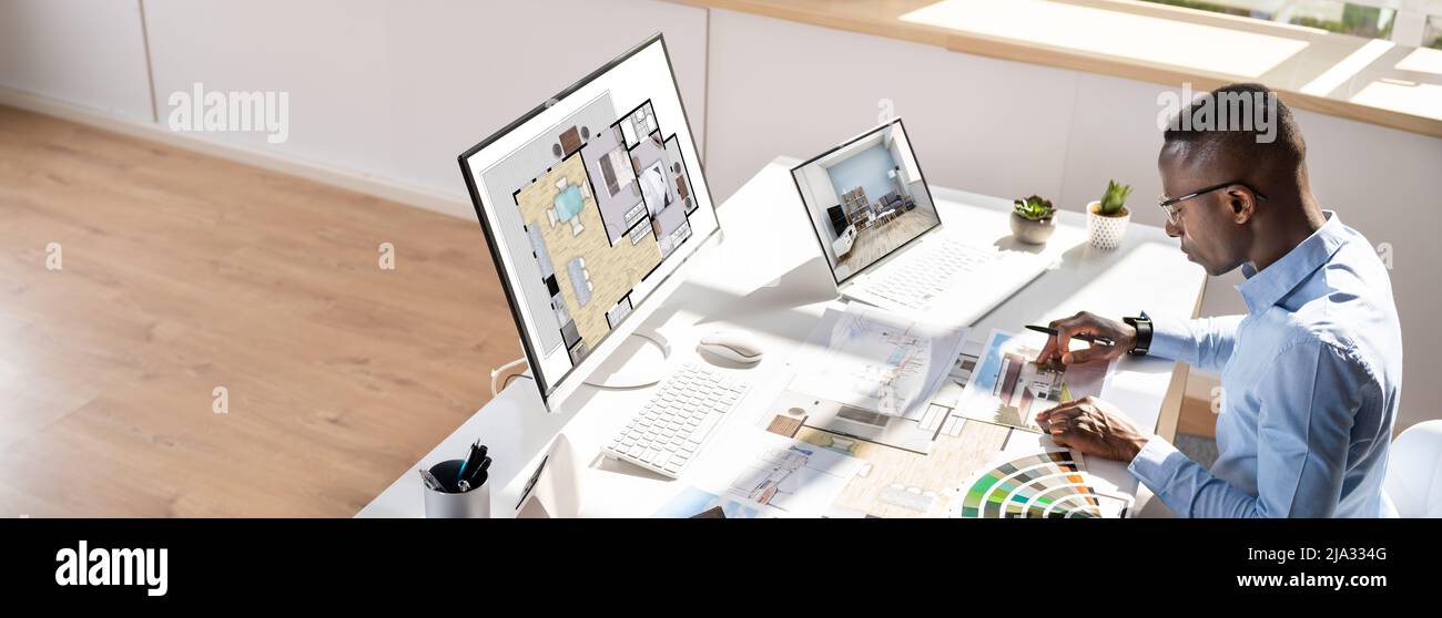 Side View Of Real Estate Designer Working On Computer In Office Stock