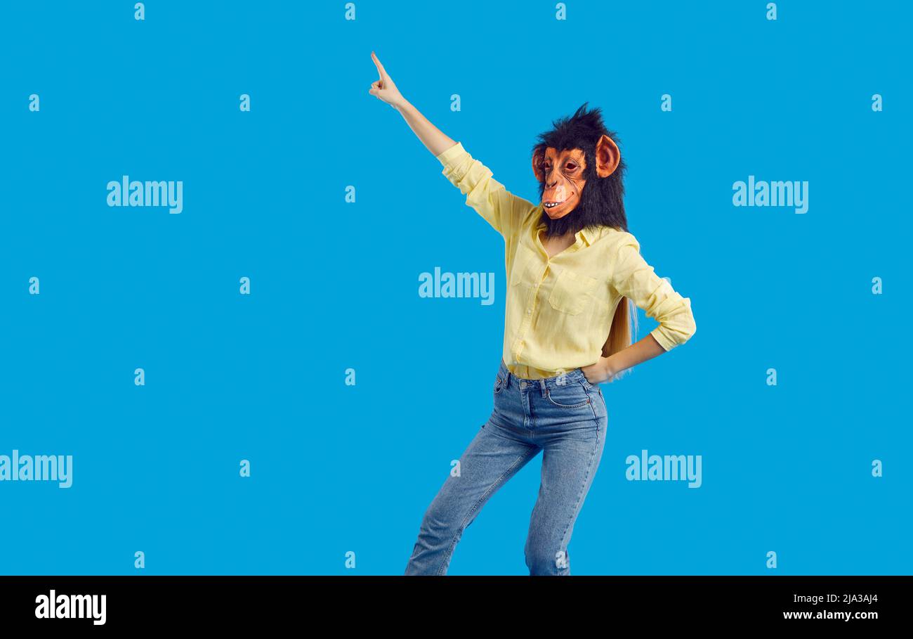 Cheerful woman funny monkey mask having fun isolated on vivid light blue background. Stock Photo