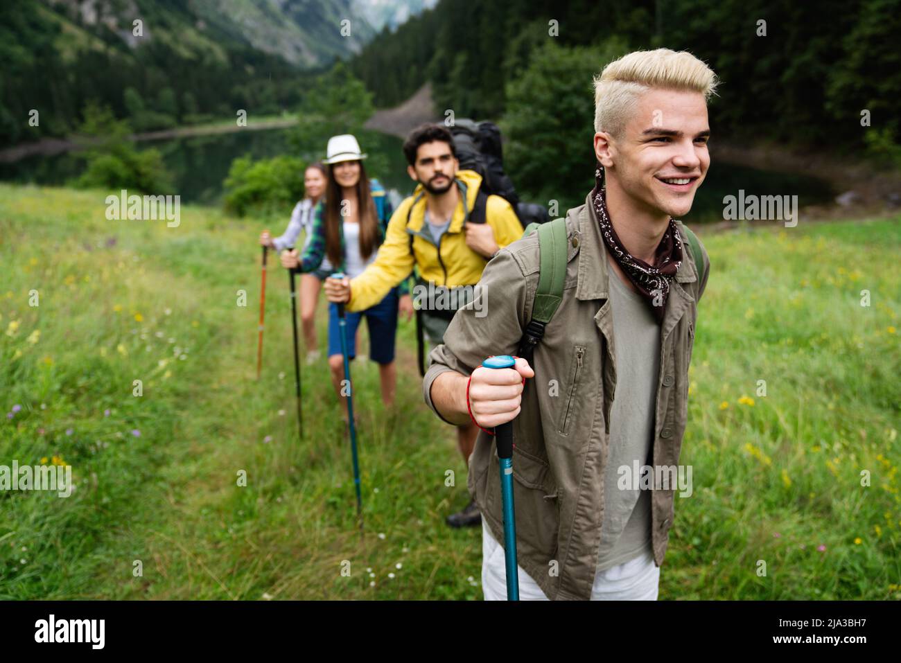 Group of young friends hiking in countryside. Multiracial happy people ...