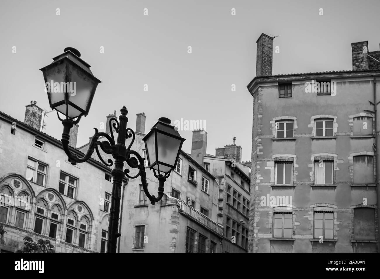 The picturesque old city of Lyon with its colorful residential buildings and vintage lamp post in black and white Stock Photo
