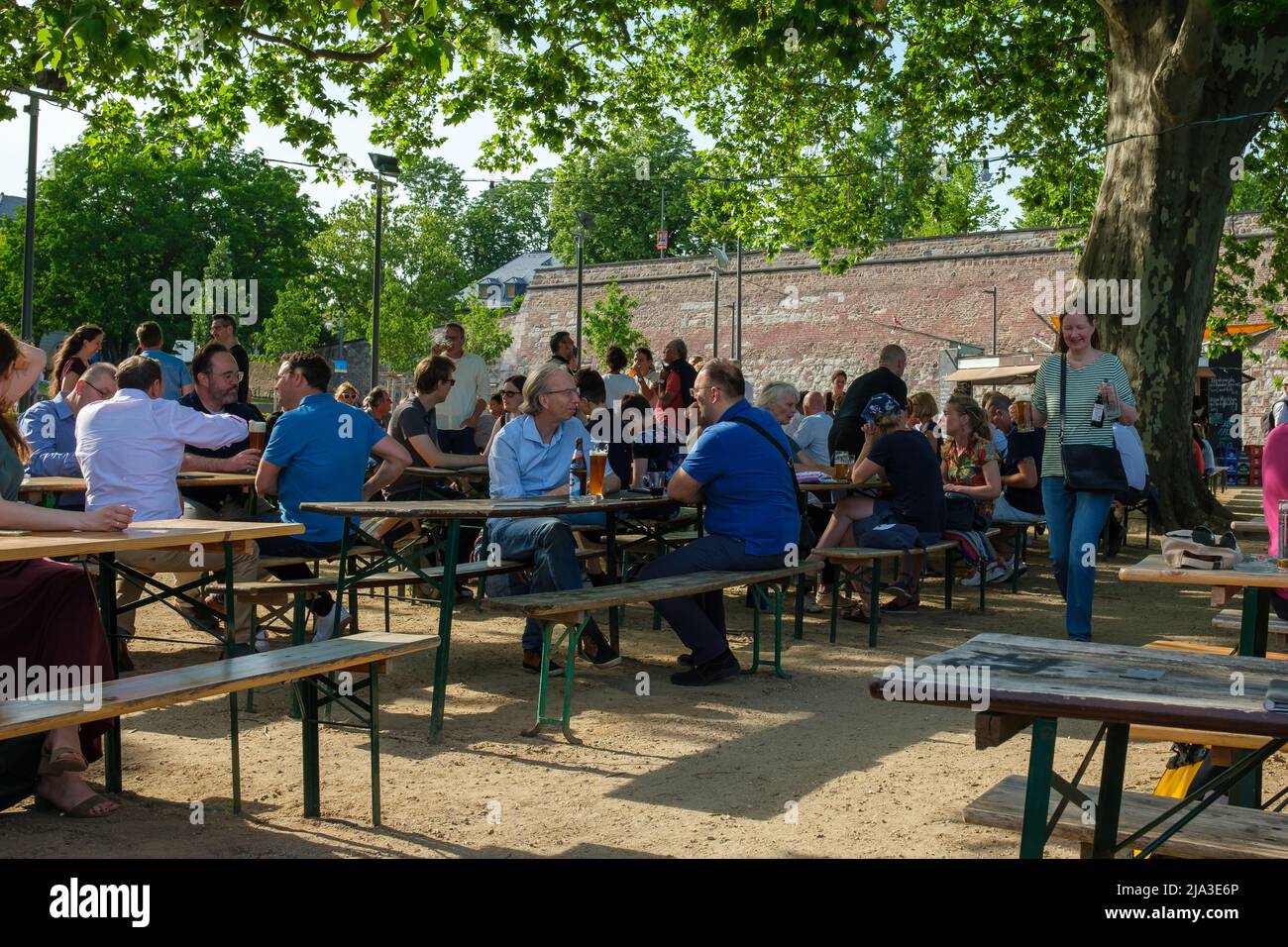 Bonn, Germany - May 18, 2022 : People enjoying cold beers and other beverages at a cozy outdoor terrace called Alter Zoll, next to the river Rhine Stock Photo
