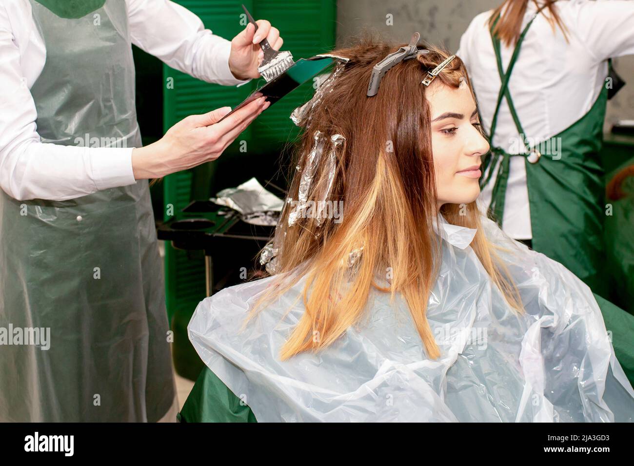 Woman coloring her hair with foil in beauty salon Stock Photo - Alamy