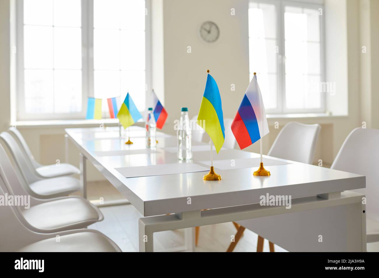 Table with flags of Ukraine and Russia at negotiation on stopping war and restoring peace Stock Photo