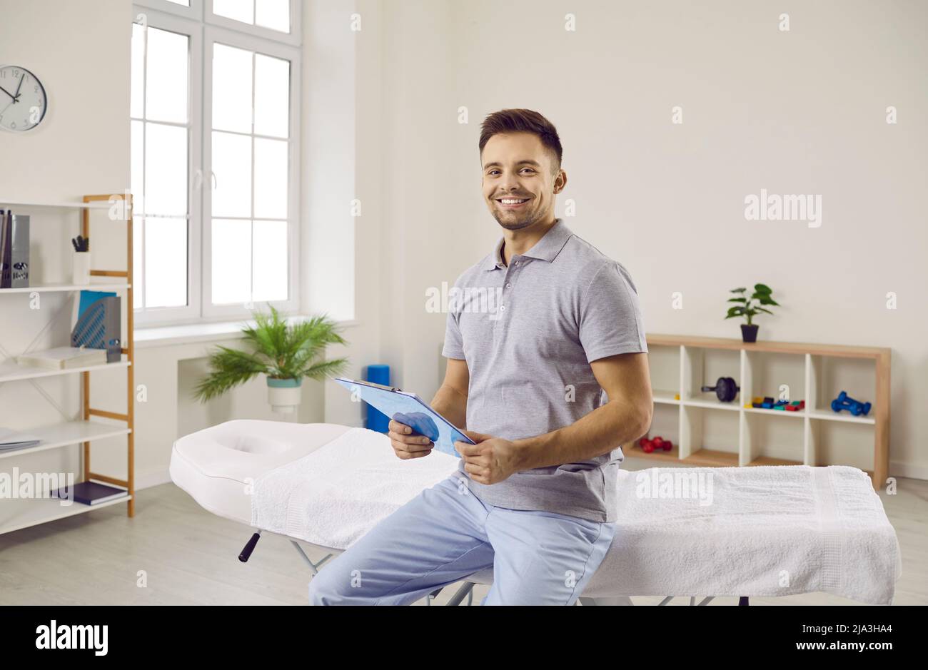 Smiling physiotherapist in medical clinic wait for patient Stock Photo