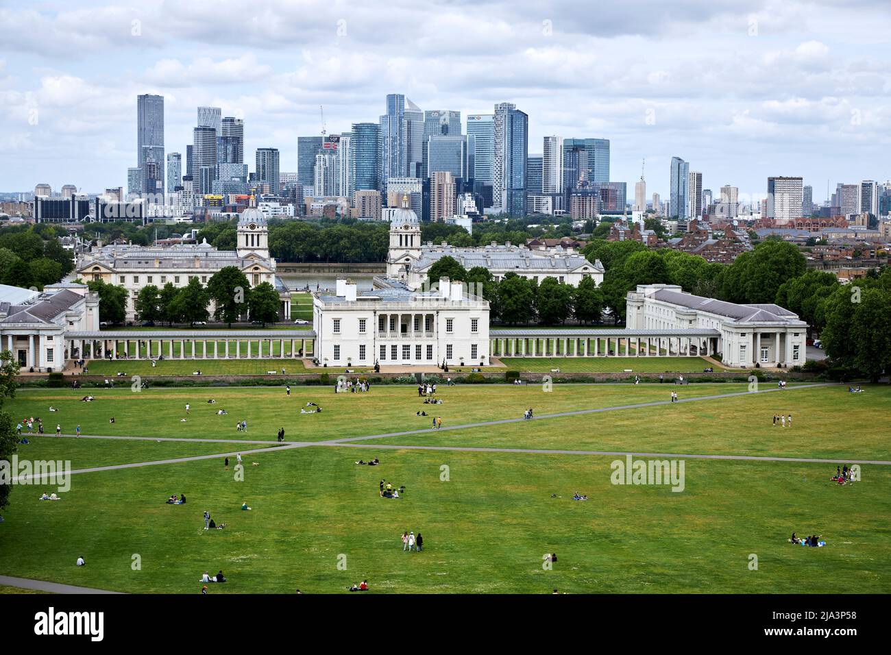 Tourists enjoy the vista with the National Maritime Museum and Queens' House, viewed from Greenwich Park, London. Stock Photo