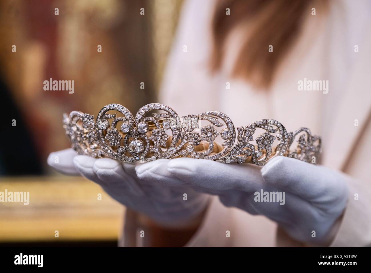 London UK, 27 May 2022. An art handler holds the Spencer tiara, worn by Princess Diana at her wedding in 1981. A loan exhibition  at Sotheby's auction house representing a rare and historic gathering of fine jewells draws together over 40 outstanding tiaras including examples of  British and European royal provenance. The exhibition runs from  28 May–15 June 2022Credit. amer ghazzal/Alamy Live News Stock Photo