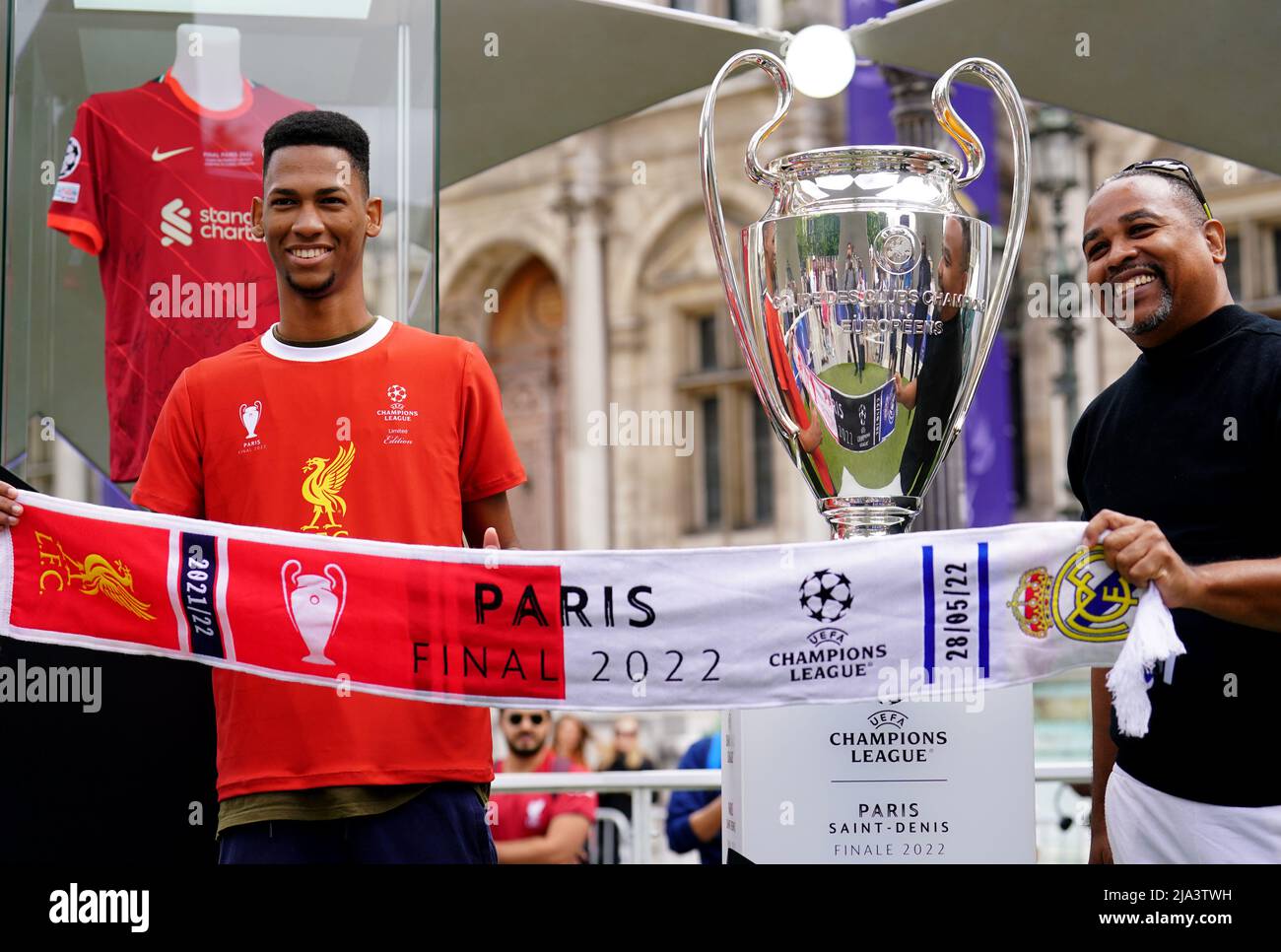 Liverpool fans pose next to the UEFA Champions League trophy at the Trophy Experience at The Place de l'Hotel de Ville in Paris ahead of Saturday's UEFA Champions League Final at the Stade de France, Paris. Picture date: Friday May 27, 2022. Stock Photo