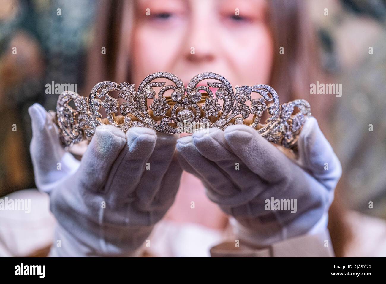 London UK, 27 May 2022. An art handler holds the Spencer tiara, worn by Princess Diana at her wedding in 1981. A loan exhibition  at Sotheby's auction house representing a rare and historic gathering of fine jewells draws together over 40 outstanding tiaras including examples of  British and European royal provenance. The ehibition: 28 May–15 June 2022Credit. amer ghazzal/Alamy Live News Stock Photo