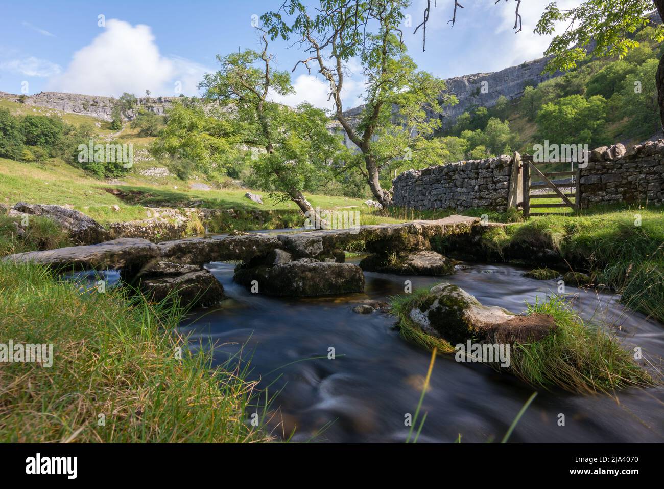 Improvised stone bridge over the stream flowing out of Malham Cove in the Yorkshire Dales. Visited during the Dales High Way long distance walk. Stock Photo