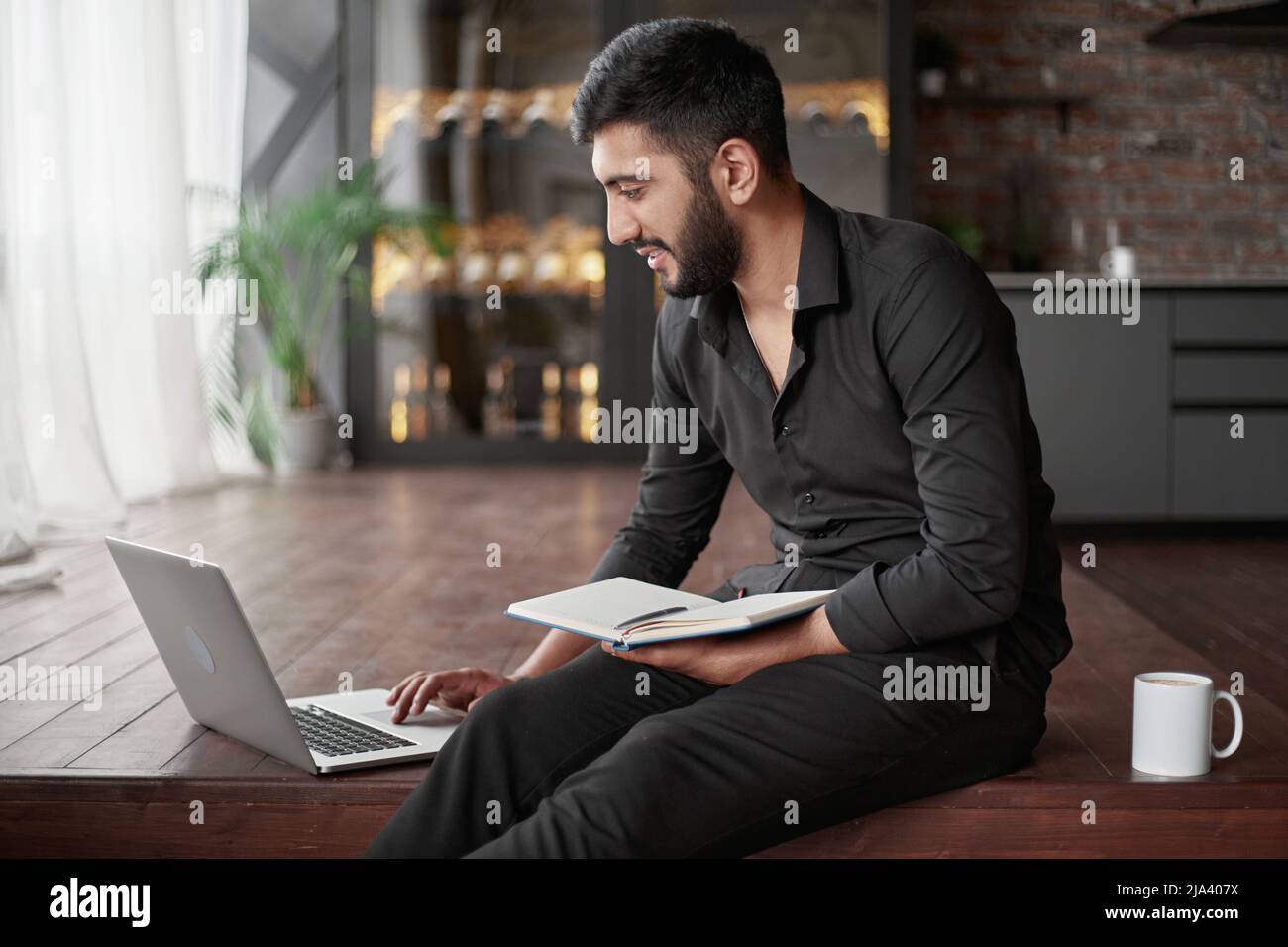 Sparknotes Owner owner of a new business is taking notes in a notebook while sitting on ...