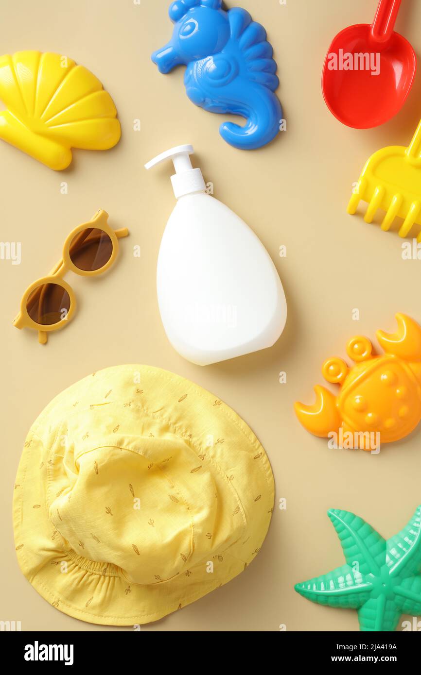 Flat lay sunscreen lotion bottle for babies and toddlers with sandbox
