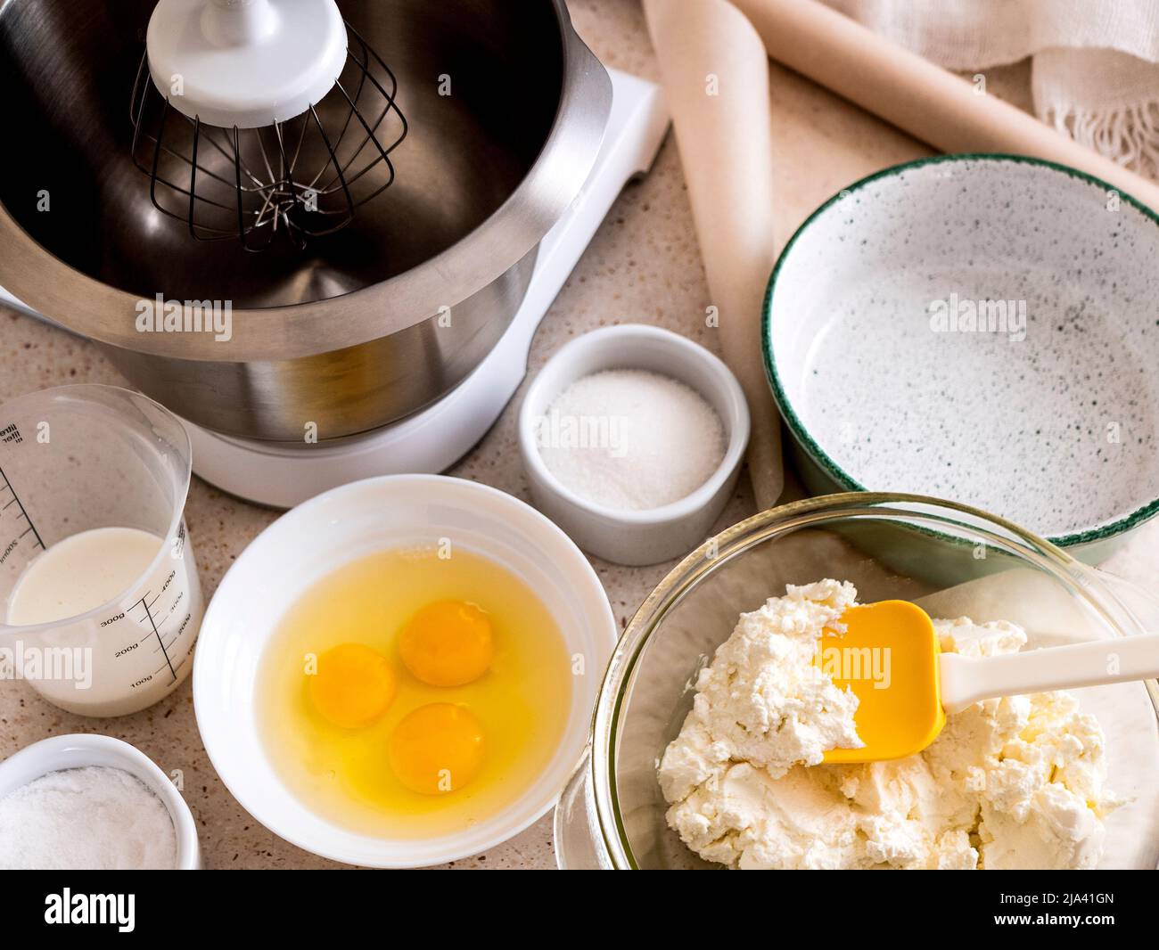 Ingredients for making cheesecake: eggs, cheese, sugar, dairy cream. Home cooking during the quarantine, selective focus Stock Photo