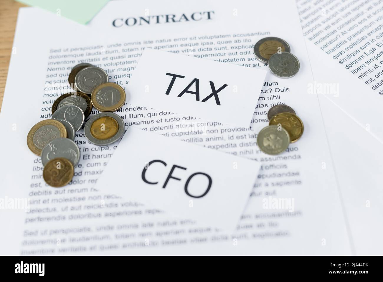 papers with tax and cfo lettering on contract with coins Stock Photo ...
