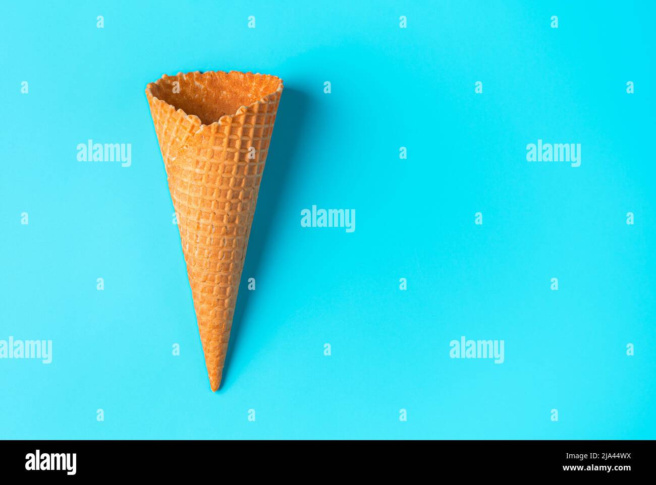 Crispy waffle cone on a blue background. View from above. Stock Photo