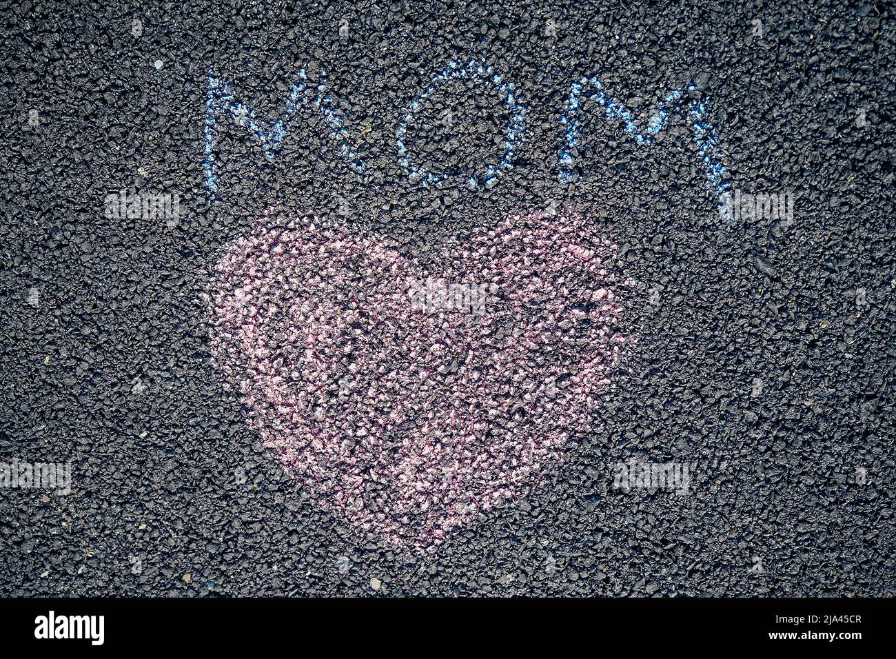 painted colored chalk crayons heart word mom on the asphalt . concept