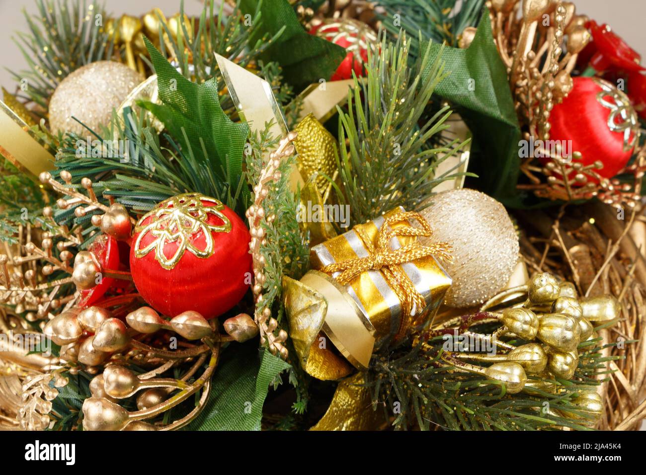 Christmas wreath with leaves, gift, ribbon and baubles Stock Photo