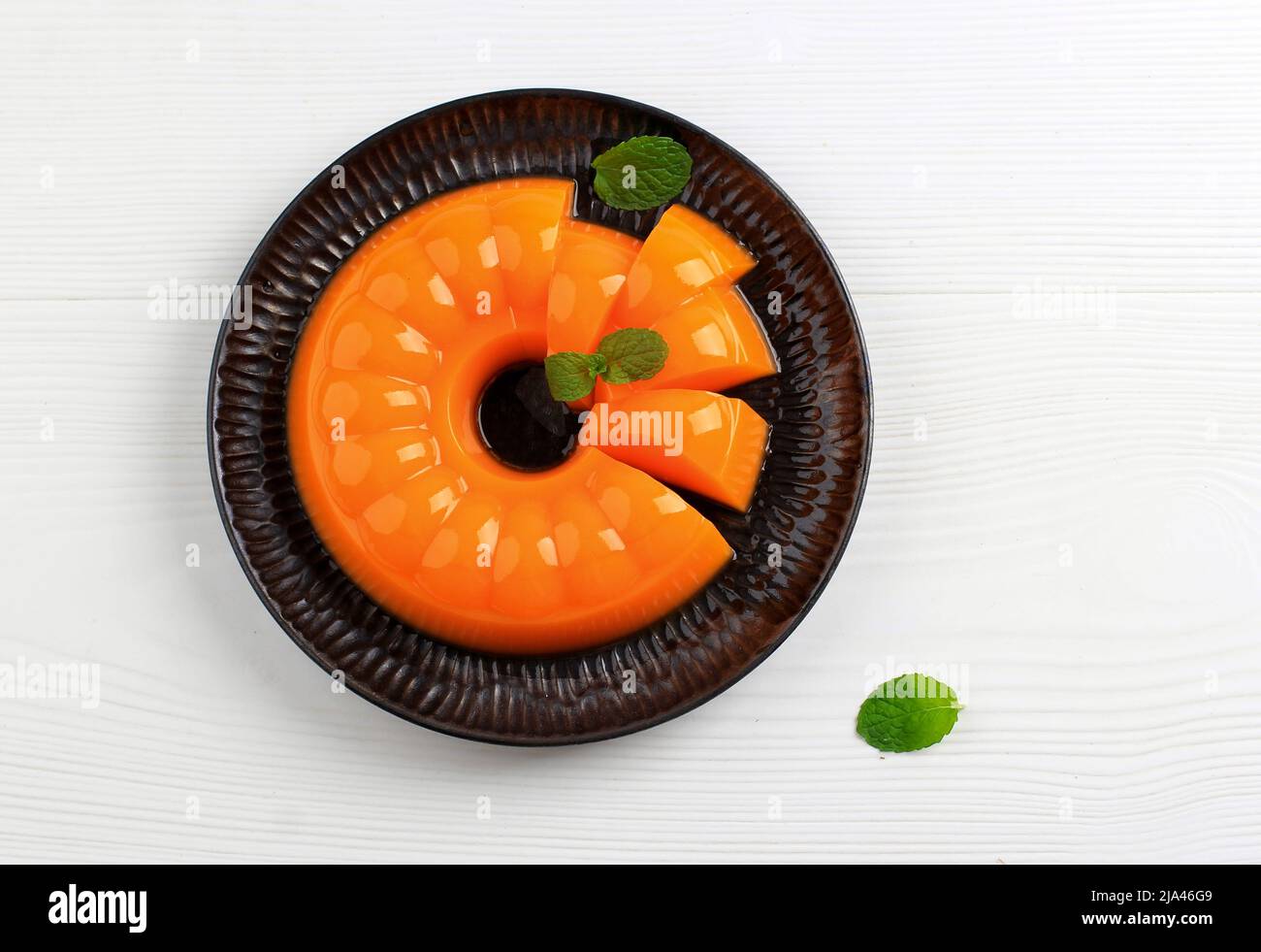 Orange Mango Pudding on Black Plate, Copy Space for Text Stock Photo