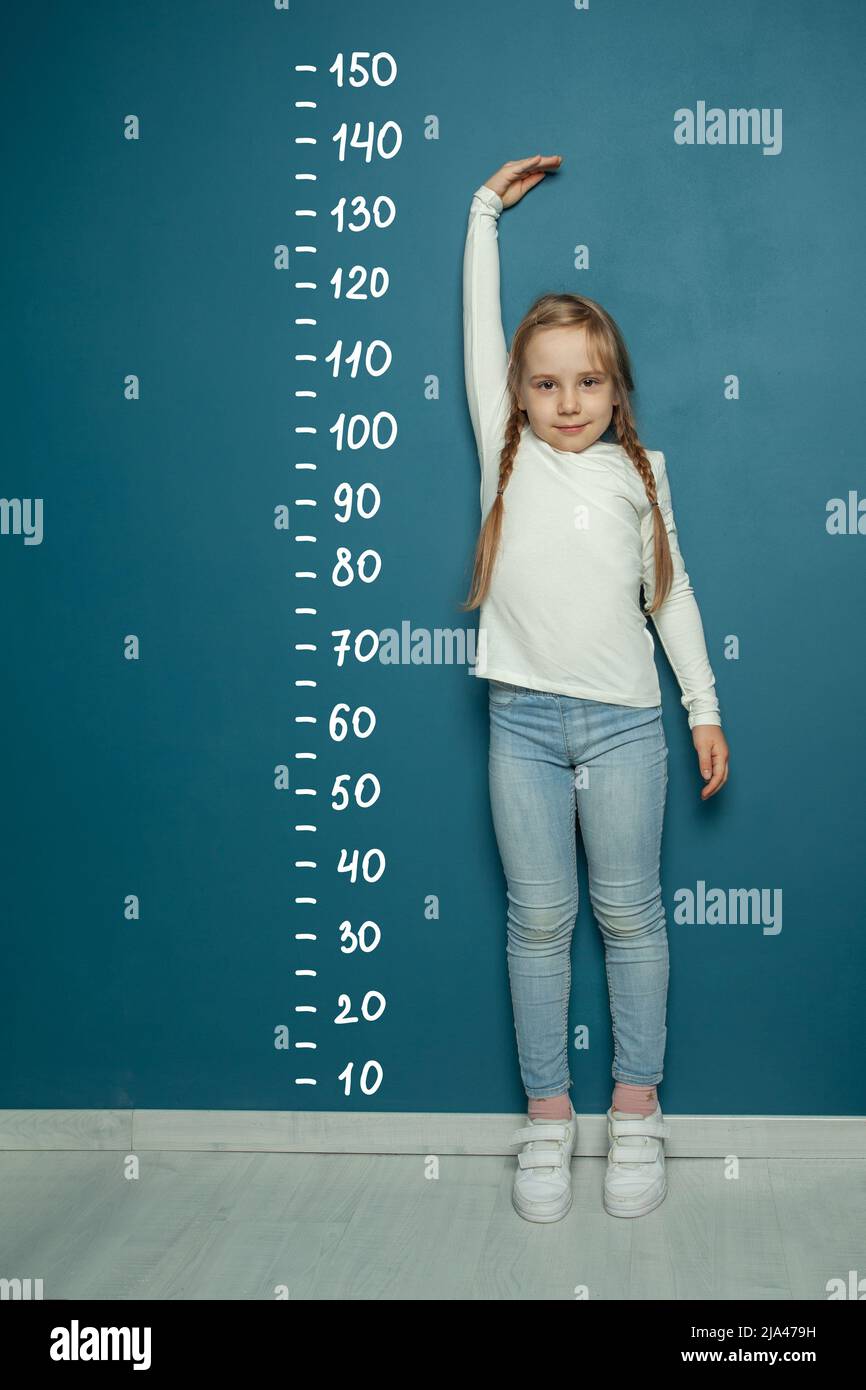 Child measure height on blue background Stock Photo