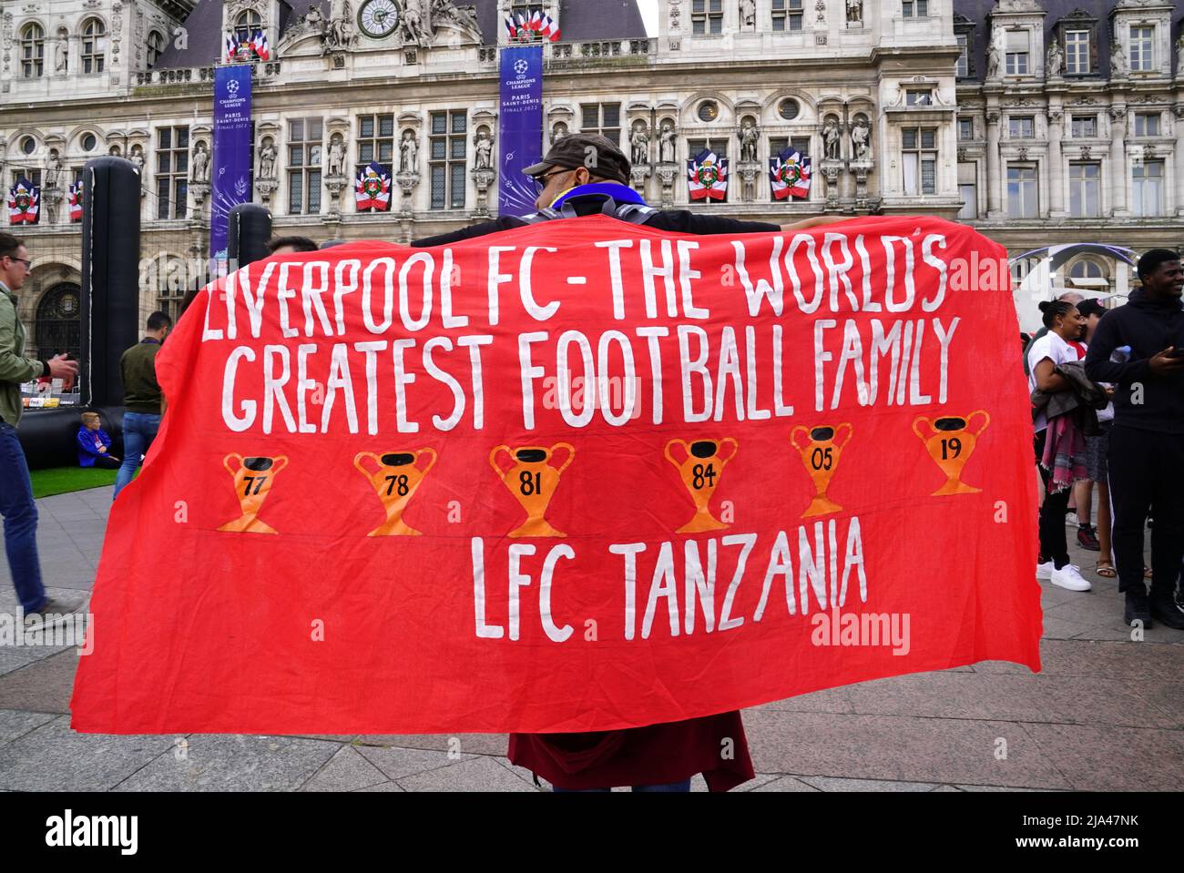 A Liverpool fan poses with a flag of support at the Trophy Experience at The Place de l'Hotel de Ville in Paris ahead of Saturday's UEFA Champions League Final at the Stade de France, Paris. Picture date: Friday May 27, 2022. Stock Photo