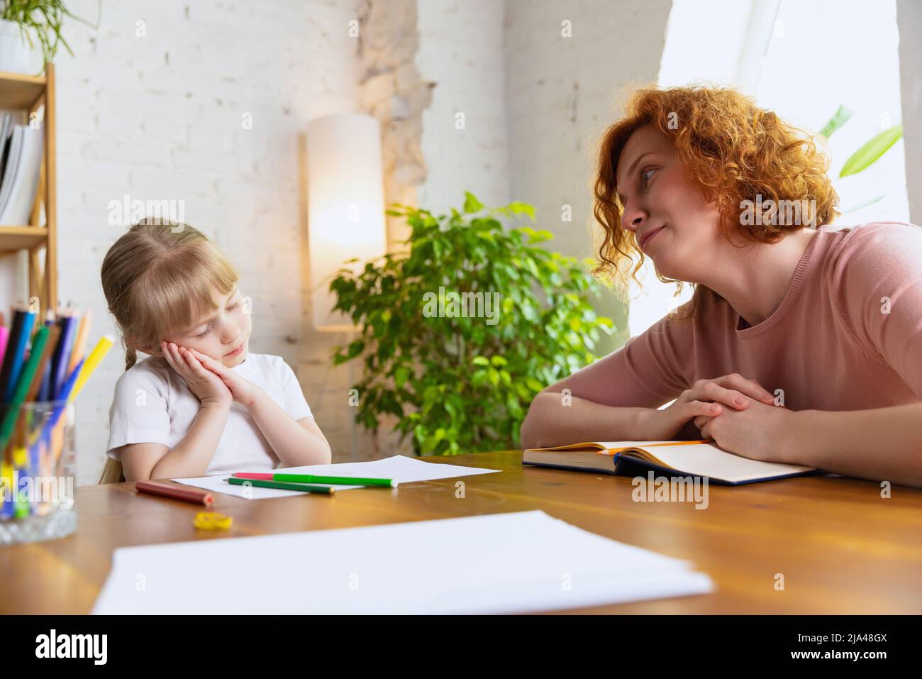 Leisure activity. Young therapist woman speaking with child, counselor and behaviour correction at the office. Drawing, counting and communicate. Conc Stock Photo