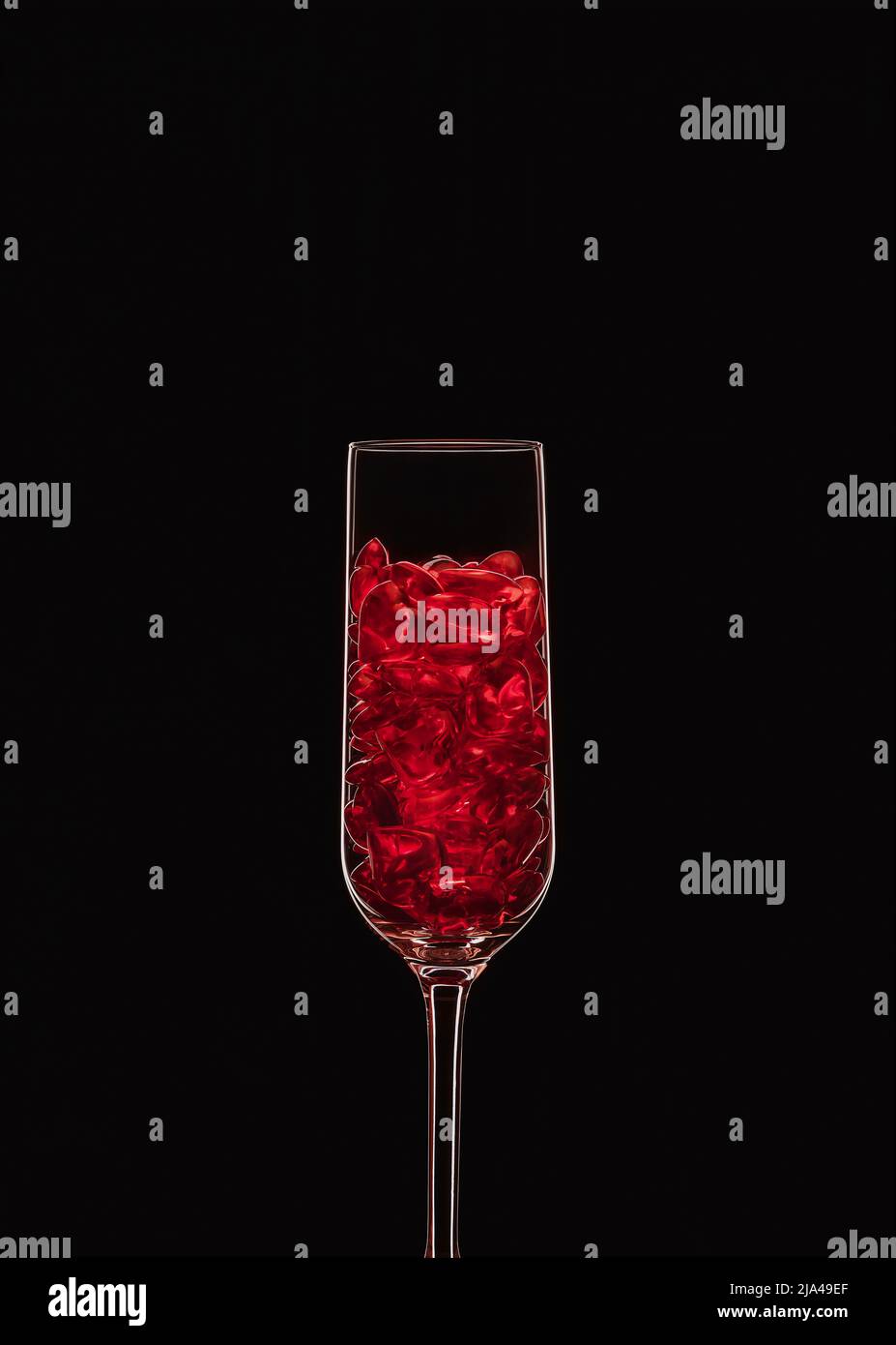 Champagne flute filled with transparent red heart shape crystals