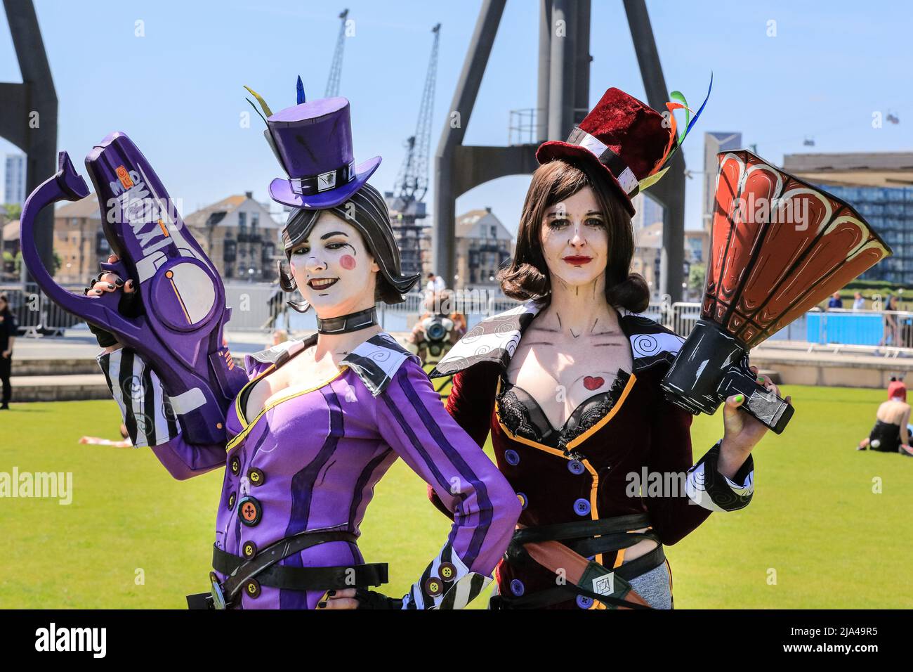 London, UK. 27th May, 2022. Mad Moxxi, two female cosplayers posing as the character from Borderlands, in red and purple outfits. Fans of anime, comics, video games, animation and all things cosplay once again gather at MCM Comic Con in and around the ExCel exhibition centre in London for a weekend of fun, stage appearances, merchandise and cosplay. Credit: Imageplotter/Alamy Live News Stock Photo