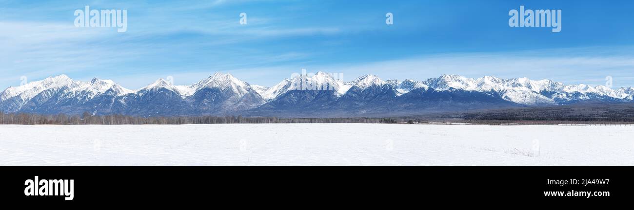 Winter landscape panorama with Sayan Mountains in Siberia on sunny winter day. Natural background. Stock Photo
