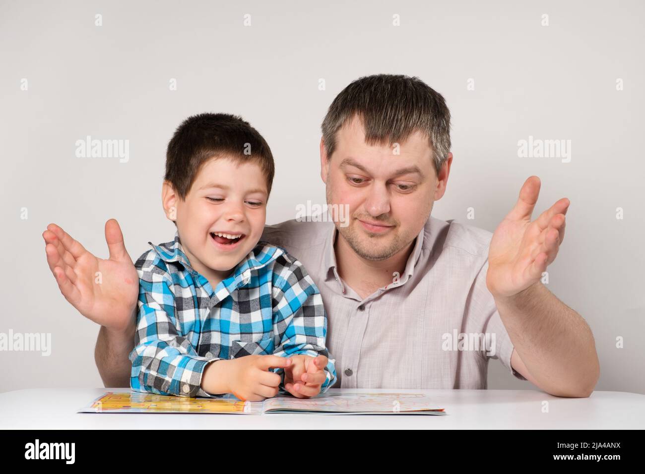 Dad teaches his son to read, names and write letters together. Parent