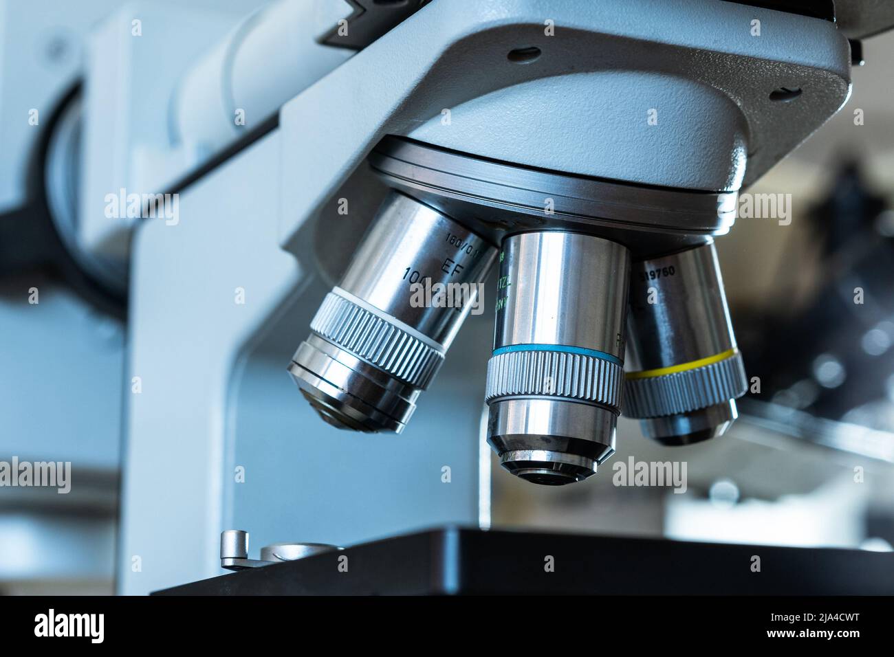 Close up of the lenses of a microscope with different magnifications in