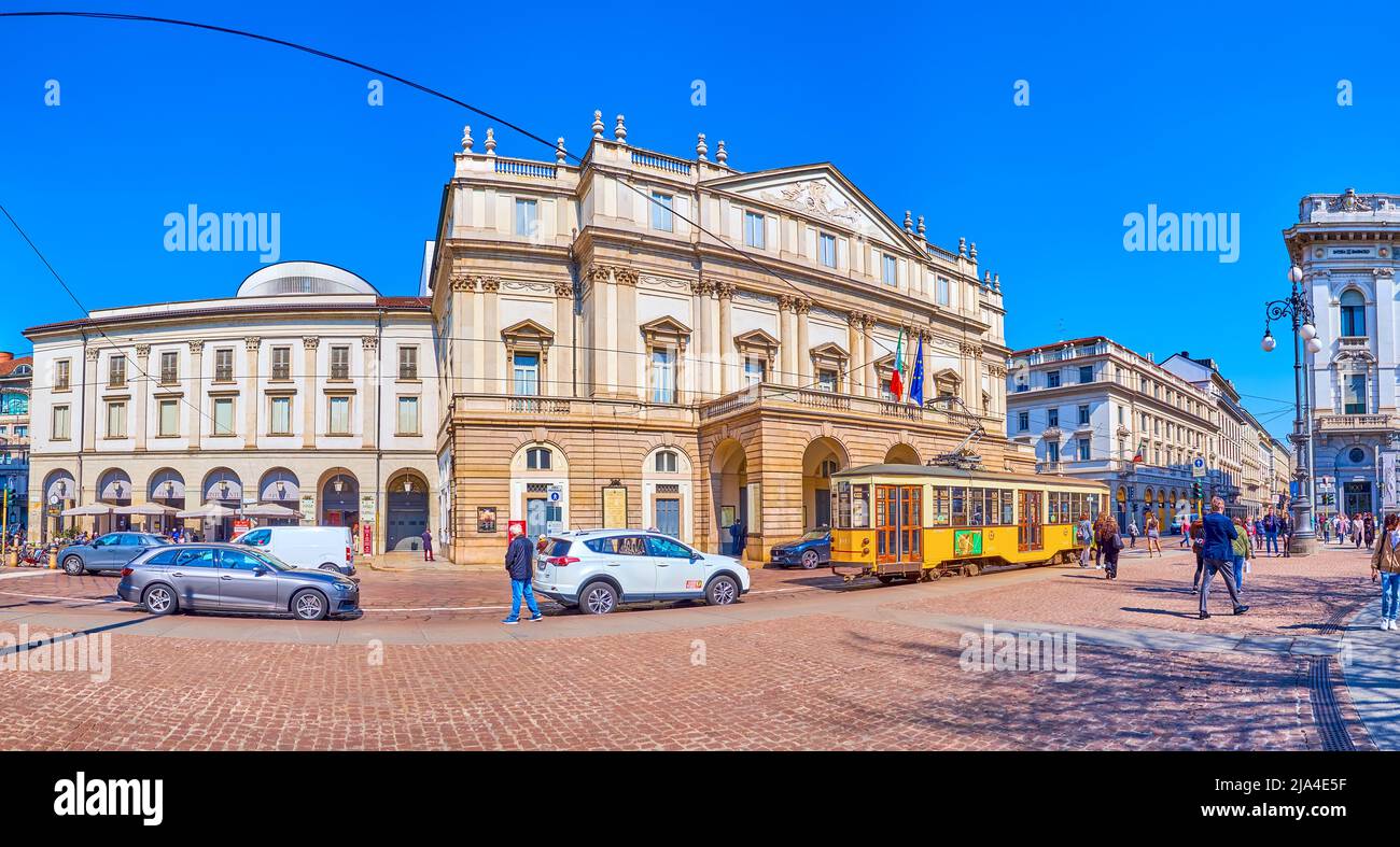 MILAN, ITALY - APRIL 5, 2022: The facade of La Scala theater and the retro styled yellow tram before it, on April 5 in Milan, Italy Stock Photo