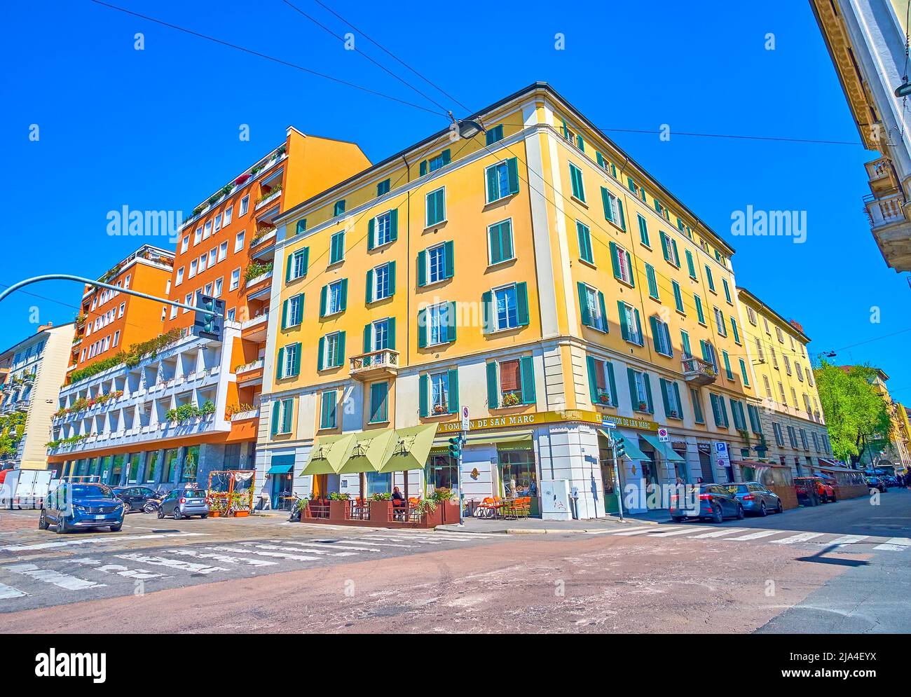 MILAN, ITALY - APRIL 5, 2022: The crossroad in Brera, the historical neighborhood of Milan with nice buildigns and numerous outdoor restaurants, on Ap Stock Photo