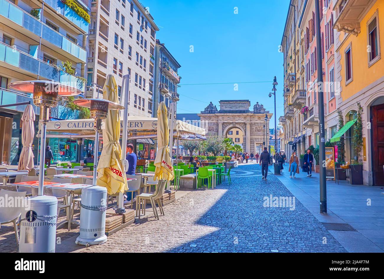 MILAN, ITALY - APRIL 5, 2022: Pedestrian Corso Como is a popular place to have a rest in aon eof numerous outdoor cafes, enjoying great view on histor Stock Photo