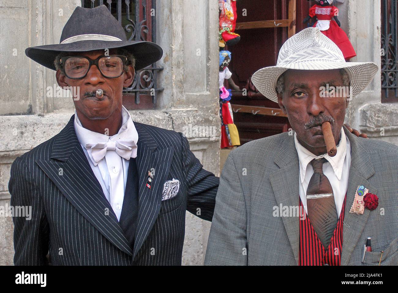 Two well dressed eldery cuban men smoking cigars, Cathedral Plaza, historic old town of Havana, Cuba, Caribbean Stock Photo