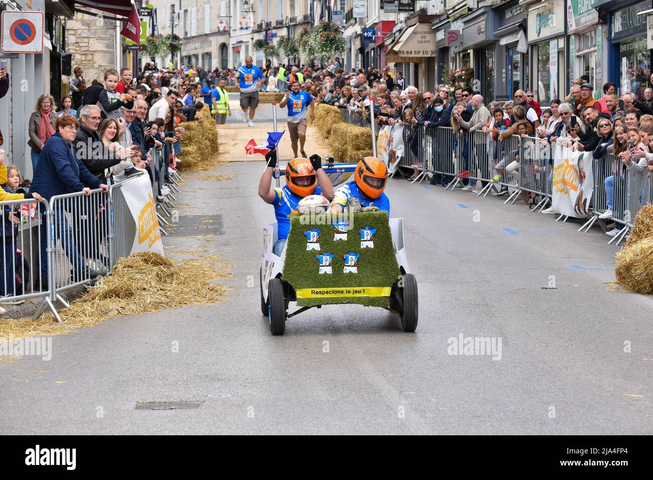 First edition of a soapbox race in the heart of the city center of Crépy-en-Valois. Homemade soap box hurtling down the slope of the main street. Stock Photo