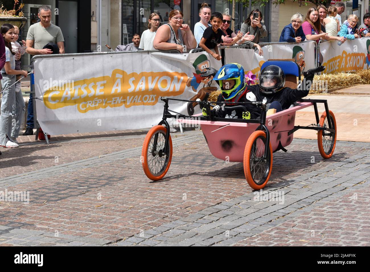 First edition of a soapbox race in the heart of the city center of Crépy-en-Valois. Homemade soap box hurtling down the slope of the main street. Stock Photo