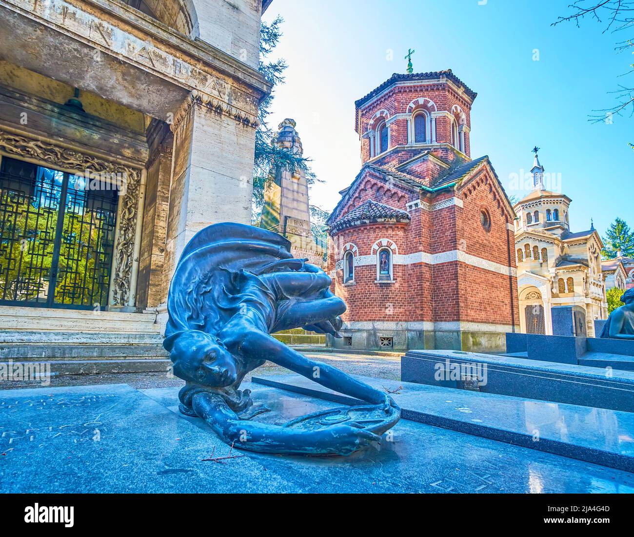 The scenic sculpture on the grave in form of thre man holding the steering wheel, Monumental Cemetery of Milan, Italy Stock Photo