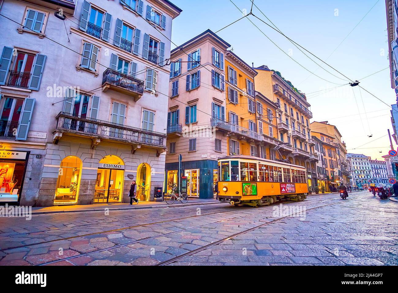 MILAN, ITALY - APRIL 5, 2022: Vintage tram rides along historical Corso Magenta street with old buildings in evening time, on April 5 in Milan, Italy Stock Photo