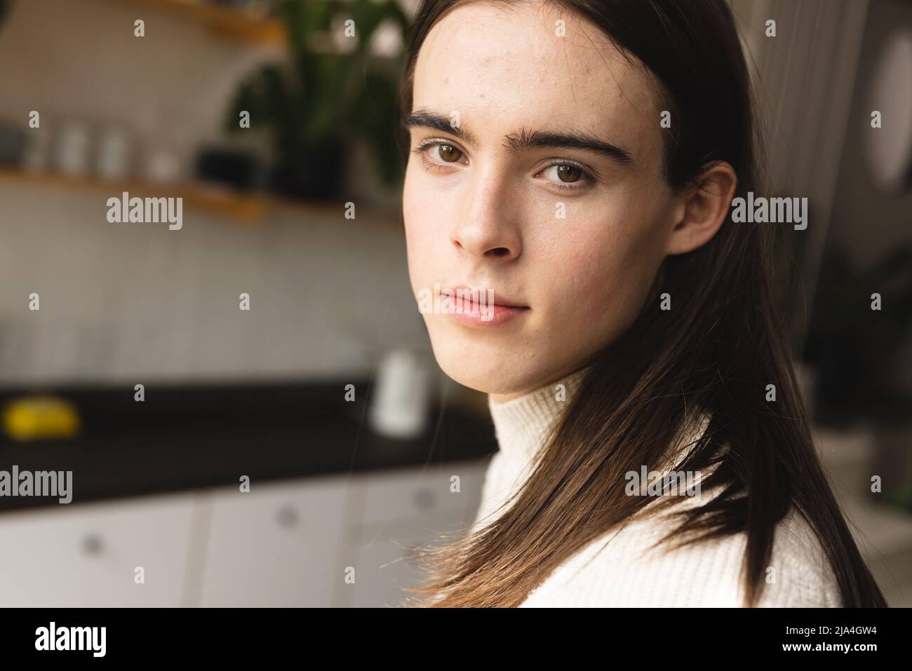 Close up portrait of non-binary trans woman in the kitchen at home Stock Photo