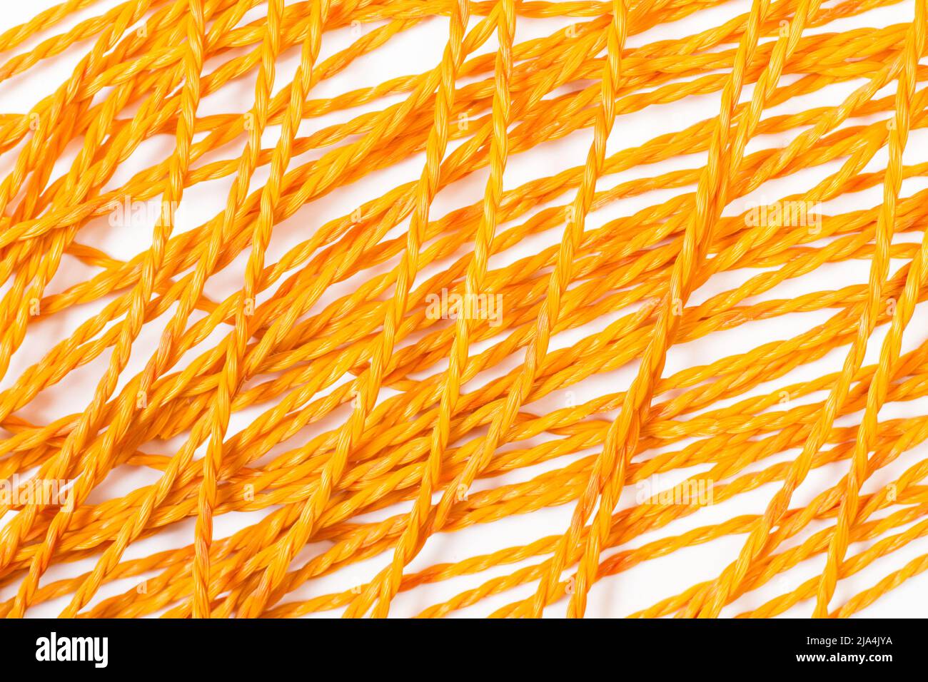 Orange plastic ropes on a white background Stock Photo - Alamy