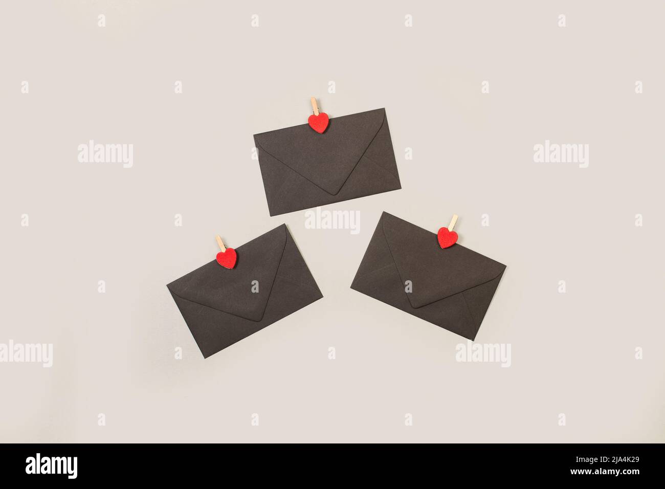 Black envelopes with red hearts on a gray background Stock Photo